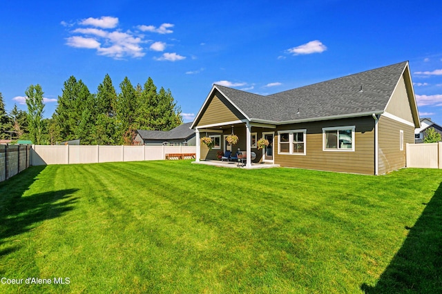 back of house with a lawn and a patio