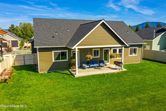 rear view of house featuring an outdoor hangout area, a lawn, a mountain view, and a patio