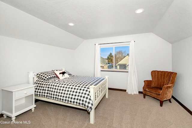 carpeted bedroom featuring vaulted ceiling and a textured ceiling