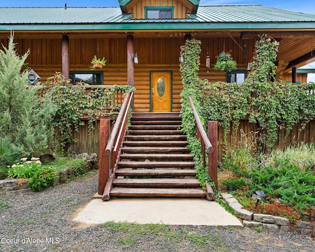 view of exterior entry featuring covered porch