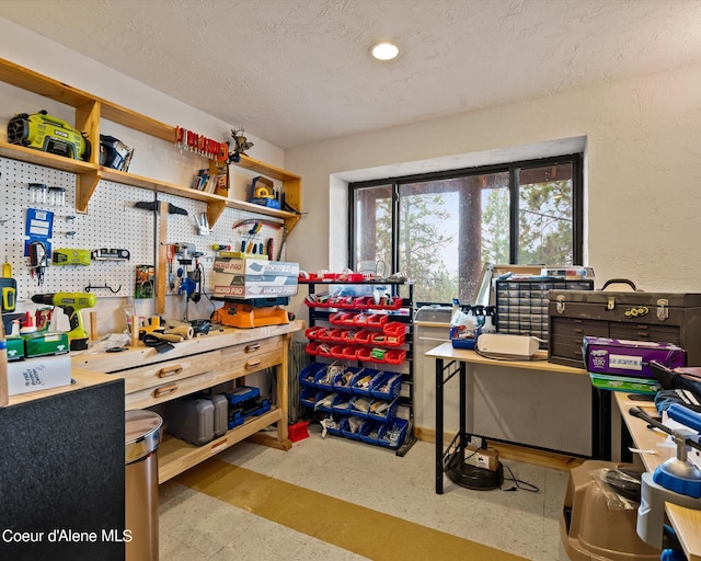 home office with a textured ceiling and a workshop area