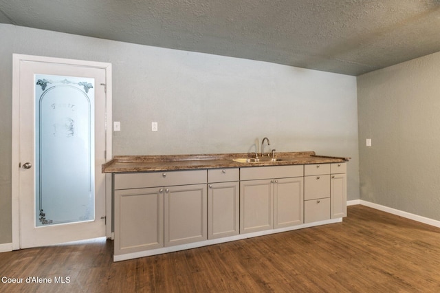 kitchen featuring sink, a textured ceiling, and dark hardwood / wood-style flooring