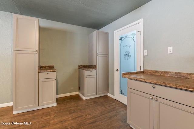 kitchen with white cabinetry, dark wood-type flooring, and a textured ceiling