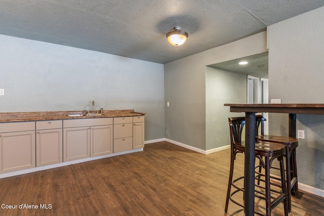 kitchen featuring sink, a textured ceiling, white cabinets, and dark hardwood / wood-style flooring