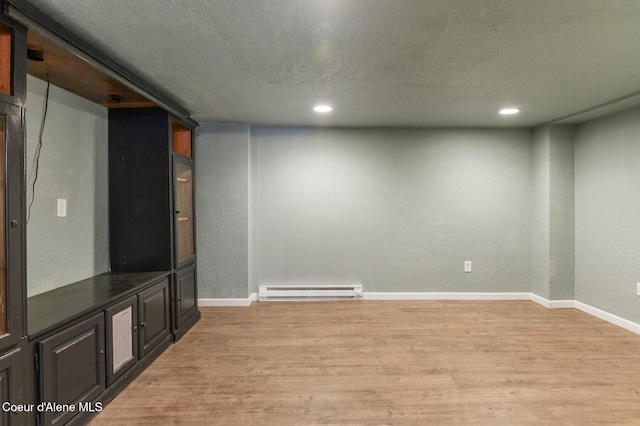 interior space with a baseboard radiator, a textured ceiling, and light hardwood / wood-style floors