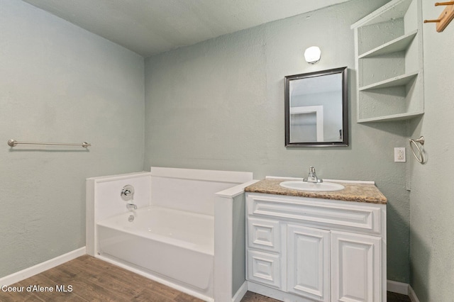 bathroom featuring wood-type flooring, a washtub, and vanity