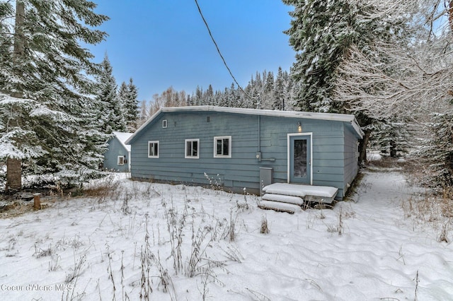 view of snow covered back of property