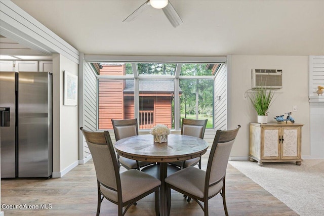 dining area with ceiling fan, a wall unit AC, and light hardwood / wood-style flooring