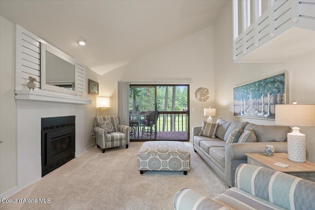 living room featuring high vaulted ceiling, a fireplace, and light colored carpet