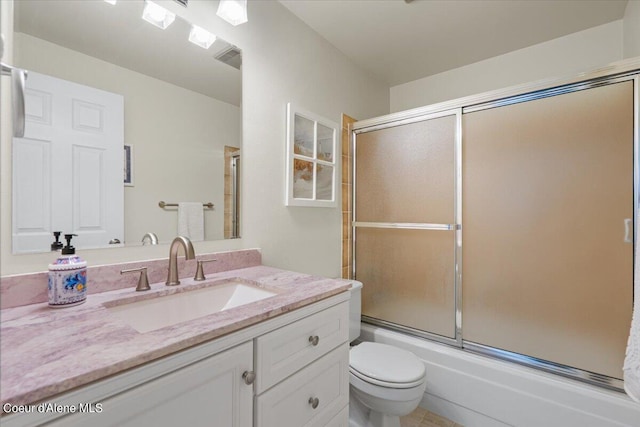 full bathroom featuring vanity, shower / bath combination with glass door, and toilet