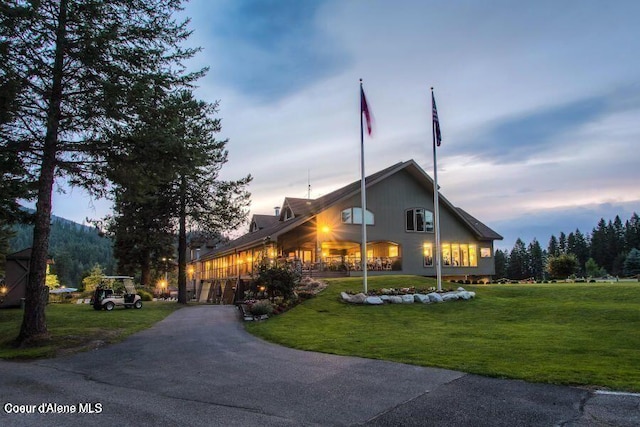 property exterior at dusk featuring a lawn