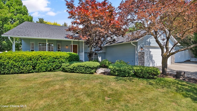 view of front facade featuring a garage, a front lawn, and a porch