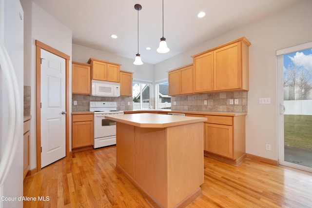 kitchen with white appliances, light brown cabinetry, a center island, and hanging light fixtures