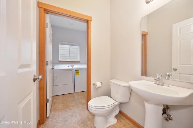 bathroom featuring washer and clothes dryer, tile patterned floors, and toilet