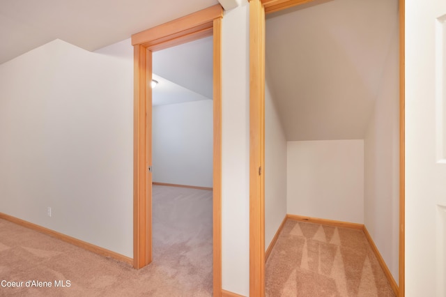 bonus room with light colored carpet and vaulted ceiling