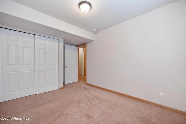 unfurnished bedroom featuring light carpet and a closet