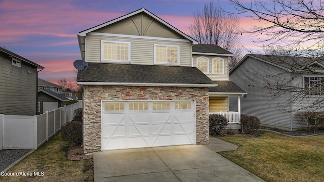 front facade featuring a garage and a yard