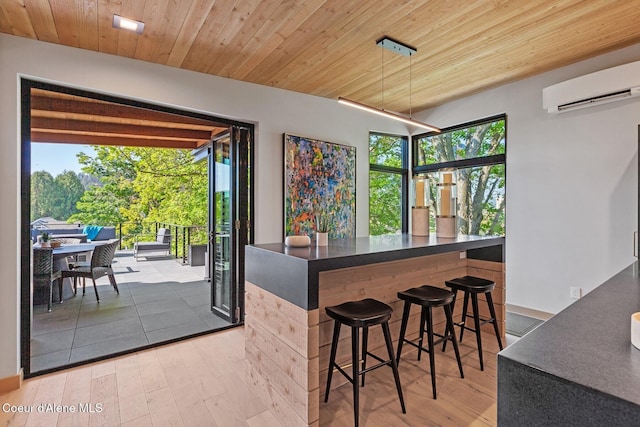 interior space with a wall mounted air conditioner, wooden ceiling, and light wood-type flooring