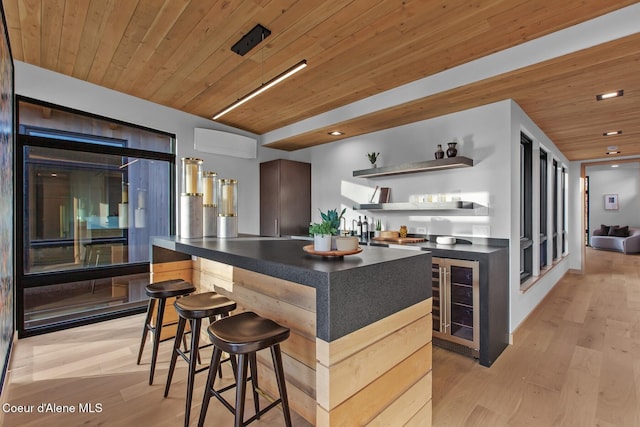 kitchen with wine cooler, a kitchen bar, light hardwood / wood-style flooring, and wooden ceiling