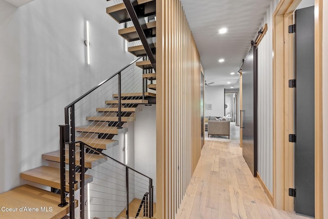 staircase with hardwood / wood-style flooring and a barn door