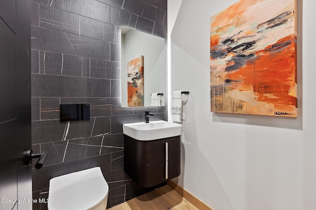 bathroom with vanity, decorative backsplash, tile walls, and toilet