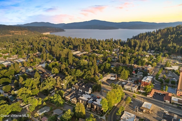 aerial view at dusk featuring a water and mountain view