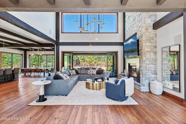 2763 E Lower Pasture Rd, Harrison, ID 83833 - living room featuring wood-type flooring, a fireplace, beam ceiling, and a high ceiling