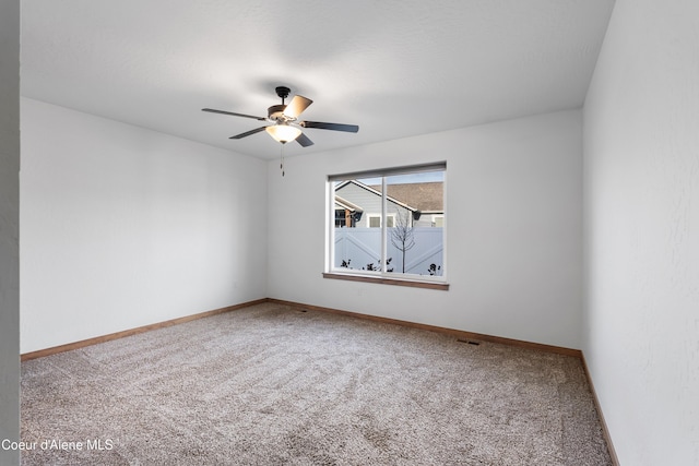 carpeted spare room with ceiling fan