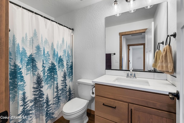 bathroom featuring vanity, a textured ceiling, and toilet