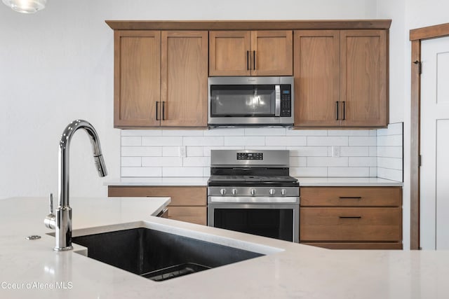 kitchen featuring appliances with stainless steel finishes, sink, and backsplash