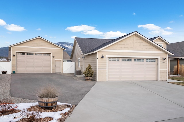 view of front facade with central AC, a garage, and a mountain view