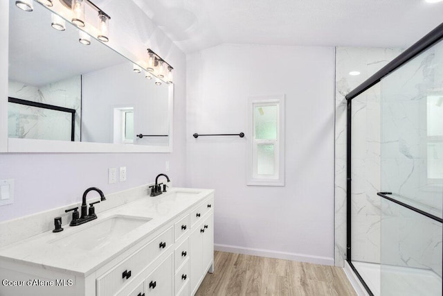 bathroom featuring hardwood / wood-style flooring, vaulted ceiling, an enclosed shower, and vanity