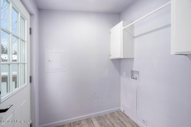 washroom featuring cabinets, hookup for a washing machine, electric panel, and light hardwood / wood-style floors