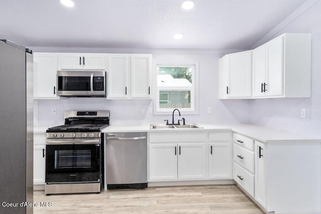 kitchen featuring white cabinetry, appliances with stainless steel finishes, light hardwood / wood-style floors, and sink