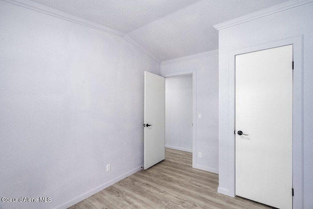 unfurnished bedroom with ornamental molding, lofted ceiling, and light hardwood / wood-style floors