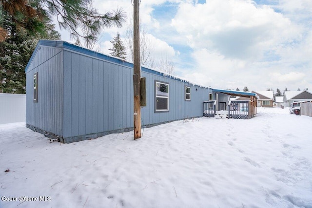 snow covered rear of property featuring a wooden deck