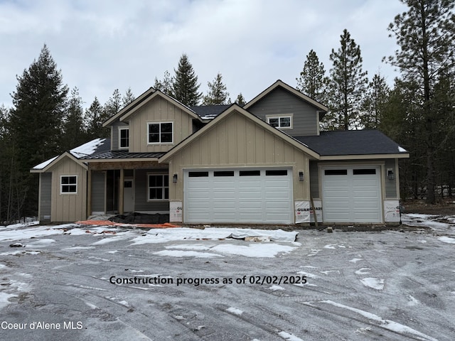 view of front of house featuring metal roof, a garage, board and batten siding, and a standing seam roof