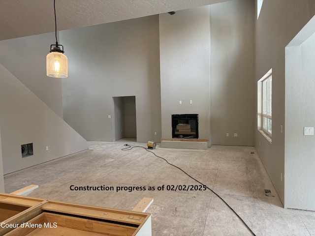 unfurnished living room featuring a towering ceiling