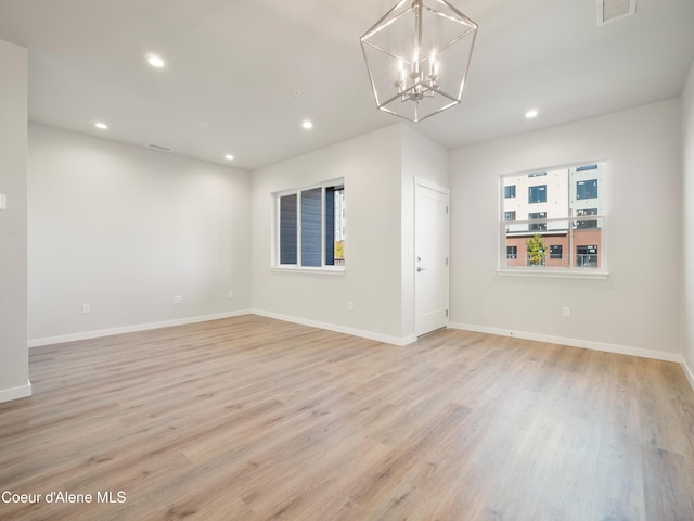 unfurnished living room featuring light hardwood / wood-style flooring and a notable chandelier