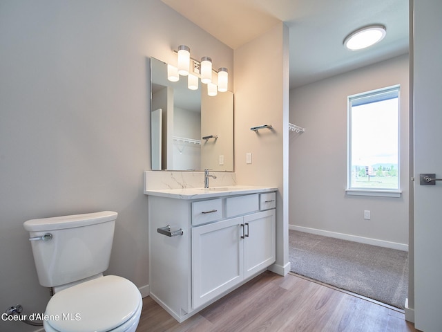 bathroom with hardwood / wood-style flooring, vanity, and toilet