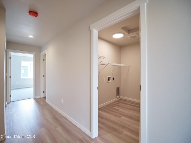 clothes washing area featuring electric dryer hookup, washer hookup, and light hardwood / wood-style flooring