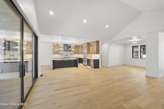 unfurnished living room with high vaulted ceiling, sink, and light hardwood / wood-style floors