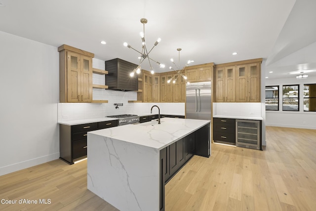 kitchen with a spacious island, wine cooler, decorative light fixtures, premium appliances, and light stone countertops