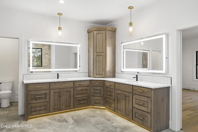 bathroom featuring vanity, toilet, and decorative backsplash