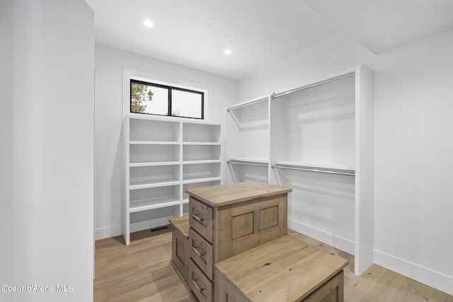 walk in closet with light hardwood / wood-style floors