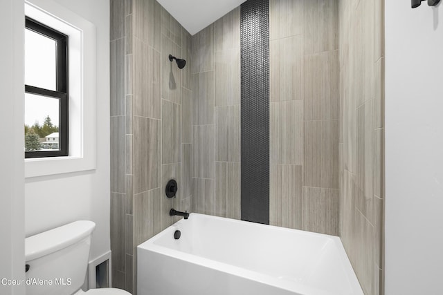 bathroom with tiled shower / bath combo and toilet