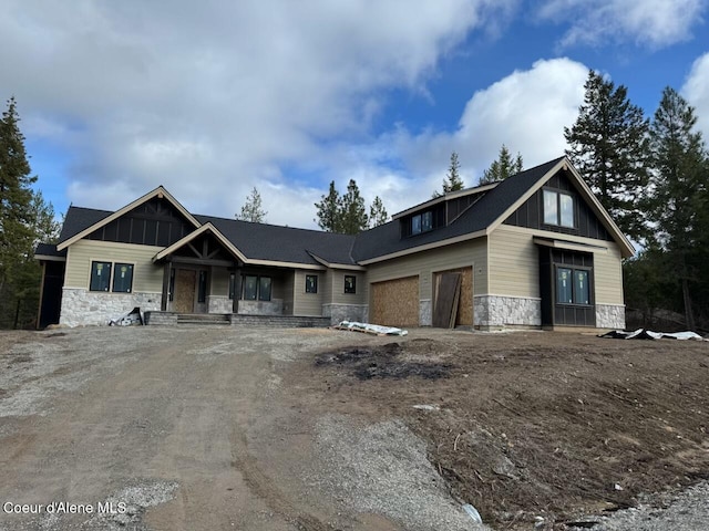 view of front of property with stone siding, driveway, and a garage