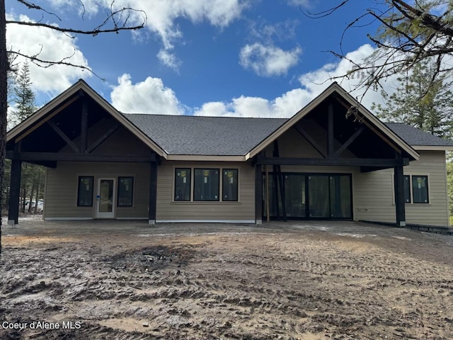 rear view of house with roof with shingles