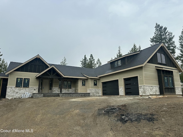 view of front facade with stone siding, aphalt driveway, board and batten siding, and an attached garage