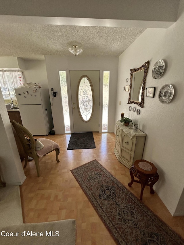 foyer entrance featuring a textured ceiling